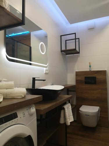 a bathroom with a sink and a washing machine at Apartments Ella in Split