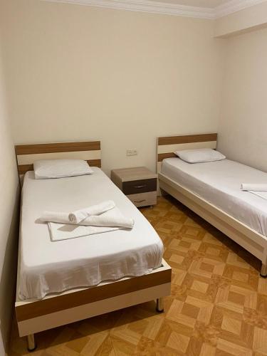 two beds with white towels on them in a room at Hotel Tao in Batumi