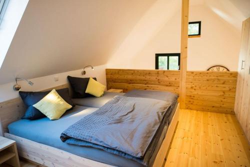 Schlafzimmer mit einem Bett mit blauer Bettwäsche und gelben Kissen in der Unterkunft Ferienwohnung 2 in Hoyerswerda