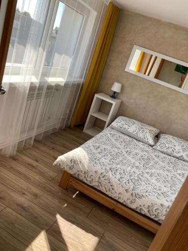 a small bedroom with a bed and a window at Apartamenty W Domu in Białystok