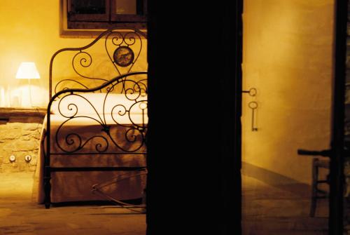 a metal bed in a room with a lamp at Relais La Torre in Chiassa Superiore