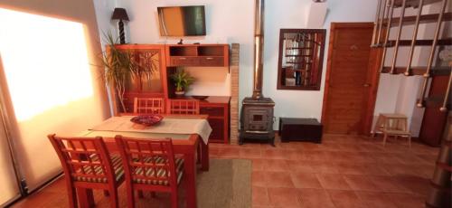 a living room with a table and chairs and a stove at Casa da Croa in Laxe