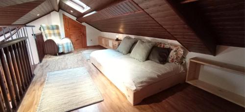 a bedroom with a large bed in a attic at Casa da Croa in Laxe