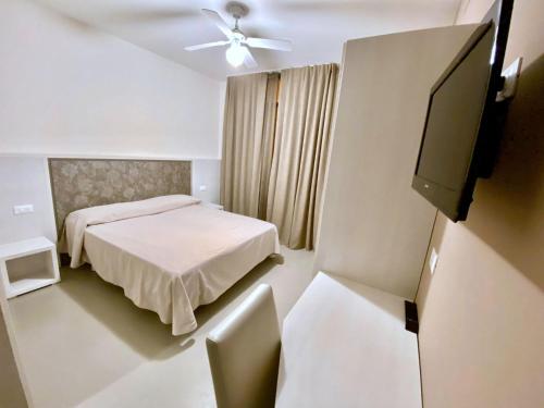 a bedroom with a bed and a flat screen tv at Hotel Maioli B&B in Misano Adriatico