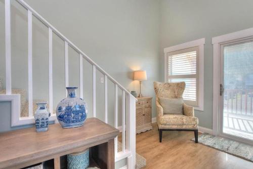 a staircase with a vase on a table and a chair at Lily Pad in Oak Island