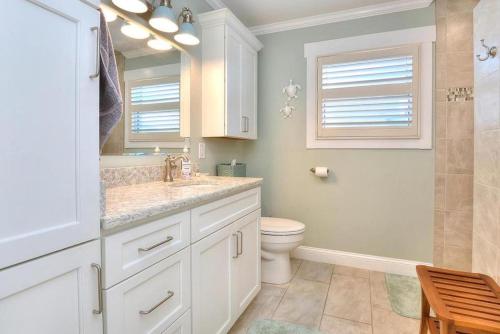 a bathroom with a sink and a toilet and a mirror at Lily Pad in Oak Island