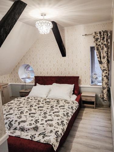 a bedroom with a black and white bed and a chandelier at Dom Weselny Pod Kasztanem in Lubań