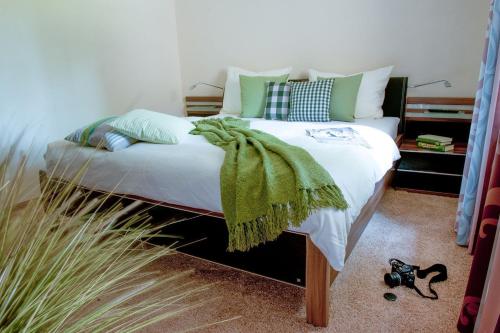 sypialnia z łóżkiem z zielonym kocem w obiekcie Ferienhaus Yvonne w mieście Otterndorf