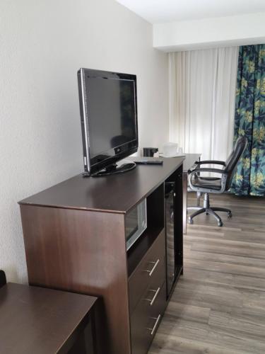 a room with a desk with a television and a chair at Quality Inn Terre Haute University Area in Terre Haute