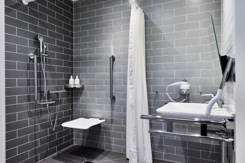 a black and white bathroom with a shower and a sink at Holiday Inn Express - Warsaw - The HUB by IHG in Warsaw