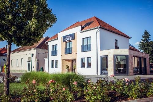 un edificio blanco con un cartel de hotel en Hotel Viktória en Sárvár