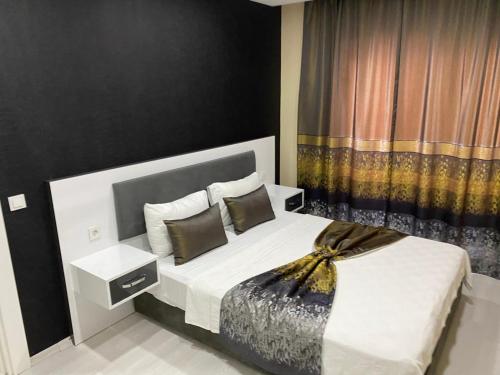 1 dormitorio con 1 cama grande y pared negra en Arya Apart Kundu Hotel, en Lara