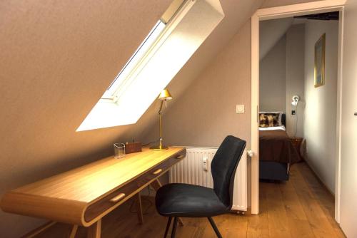 einen Schreibtisch und einen Stuhl in einem Zimmer mit Fenster in der Unterkunft Apartmenthaus am Dom Junior Suite mit Parkplatz in Zwickau