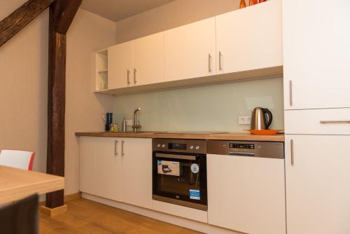 uma cozinha com armários brancos e um forno em Apartmenthaus am Dom Junior Suite mit Parkplatz em Zwickau