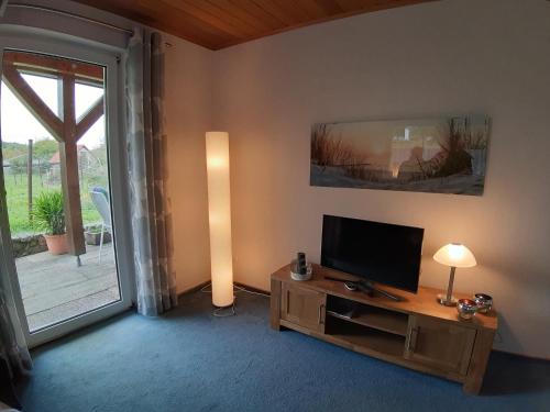 sala de estar con TV de pantalla plana sobre una mesa de madera en Ferienwohnung Elisabeth, en Egloffstein
