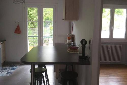 une cuisine avec une table et des chaises dans une pièce dans l'établissement superbe appartement T3 traversant avec place de parking, à Rodez