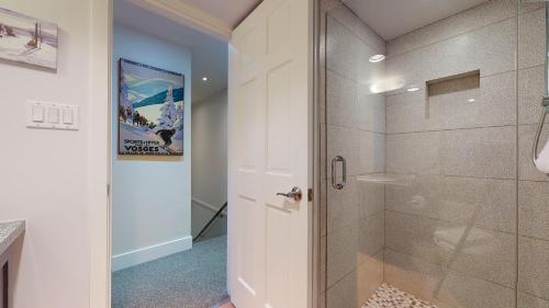 a bathroom with a shower with a glass door at Modern Home with Forested Views by Harmony Whistler in Whistler
