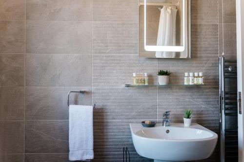 a bathroom with a sink and a mirror at Armada Cottages in Spanish Point