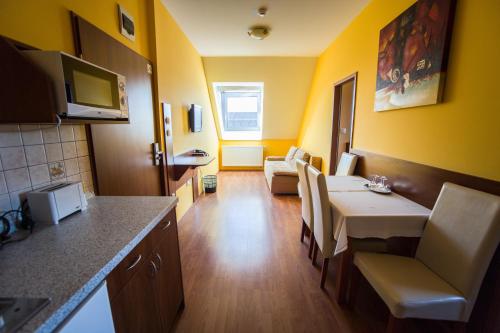 a small room with a kitchen and a dining room at Hotel Viktória in Sárvár