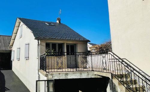 Saint-Sauveur-de-Peyre的住宿－Chez Routcho，带阳台的大楼,有屋顶