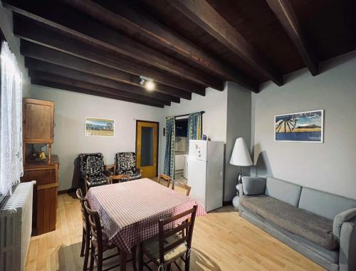 Chez Routcho في Saint-Sauveur-de-Peyre: مطبخ وغرفة معيشة مع طاولة وأريكة