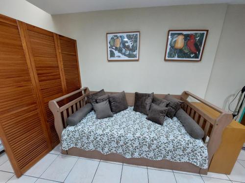 una camera da letto con un letto con cuscini di Flat beira mar, Olinda 4 Rodas 305 a Olinda