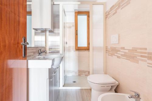 Baño blanco con aseo y lavamanos en Casa Vacanza S'Archittu, en S'Archittu