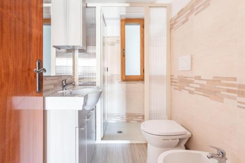 un bagno bianco con un water e un lavandino di Casa Vacanza S'Archittu a S'archittu Cuglieri