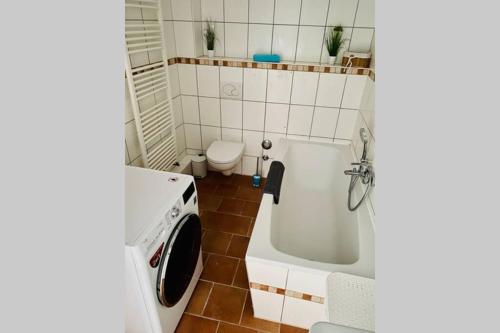 a small bathroom with a tub and a toilet at FeWo Seestadt mit Balkon in Goslar