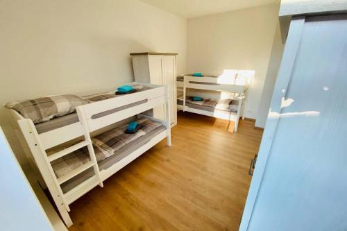 two bunk beds in a room with wooden floors at FeWo Seestadt mit Balkon in Goslar