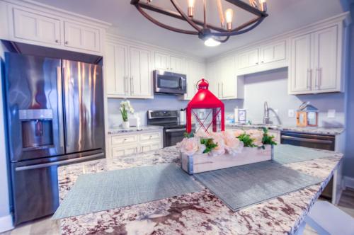 a kitchen with white cabinets and a red lantern on a counter at BRAND NEW! Laketown Wharf 633! Amazing 3 BD, Great Location, And Awesome Amenities! in Panama City Beach