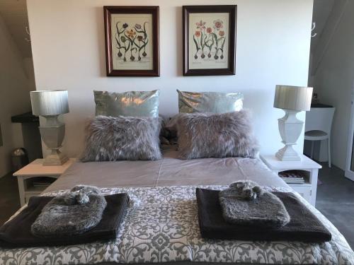 a bedroom with a bed with two pillows on it at La Maison Bleue, luxury self-catering villa. in Langebaan