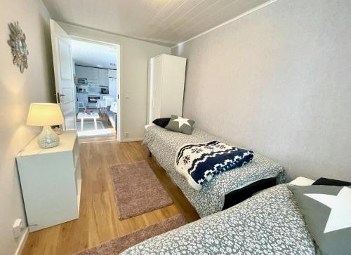 a room with two beds and a living room at Cozy renovated house with a lot of parking space. in Haparanda