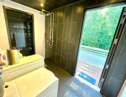 a bathroom with a shower and a toilet and a window at Cozy renovated house with a lot of parking space. in Haparanda