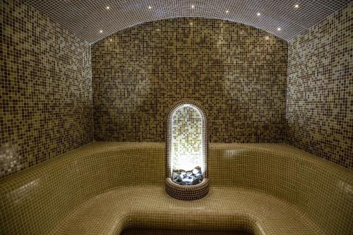 a room with a bath tub with a window in it at Hotel Park Shtip in Štip