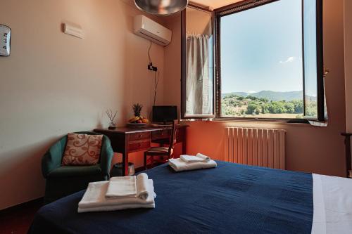 a room with a bed and a chair and a window at Il Pozzo Country House in Collescipoli