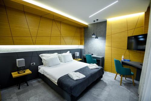 a hotel room with a bed and a desk and a tv at Hotel Park Shtip in Štip