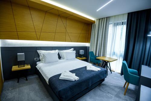 a hotel room with a bed and a table and chairs at Hotel Park Shtip in Štip