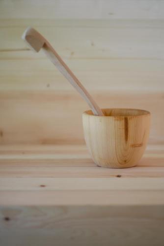 a spoon in a wooden bowl on a table at Garnì Aurora Bed and Breakfast in Soraga