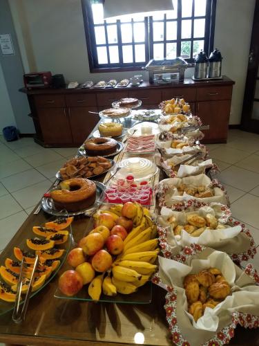 a long table filled with different types of food at Pousada Finlândia in Penedo