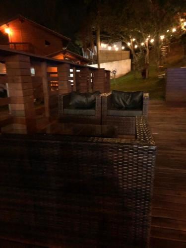 a bench with two pillows on a patio at night at Pousada Farol do Arvoredo in Governador Celso Ramos