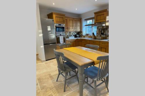 a kitchen with a wooden table and chairs at Charming, cosy waterside retreat in Gimingham, North Norfolk in Gimingham