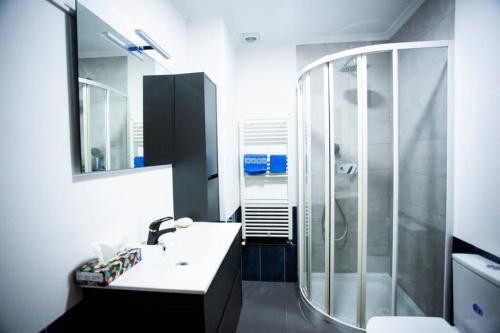 a bathroom with a sink and a glass shower at Piso luminoso y tranquilo en Ourense (O Couto) in Ourense