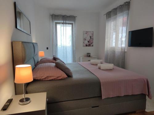 ein Schlafzimmer mit einem großen Bett und einem TV in der Unterkunft Apartment Sve u 5 minuta in Zadar