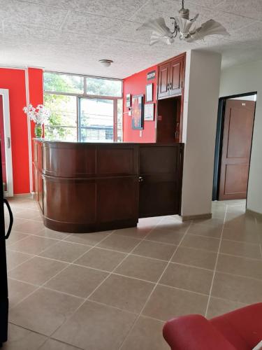 a living room with red walls and a brown counter at hotel villa morenta in Yopal