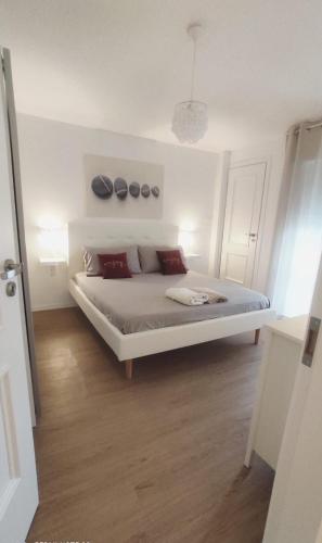 a bedroom with a white bed with red pillows at Greta a mare in Montesilvano