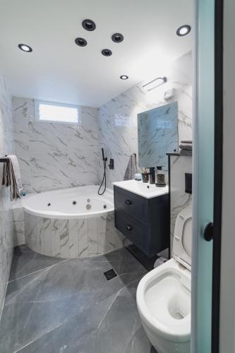 a bathroom with a tub and a toilet and a sink at Orel suite in Eilat