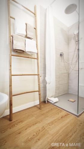 a bathroom with a shower with a ladder and towels at Greta a mare in Montesilvano