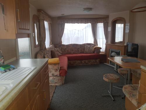 uma cozinha e uma sala de estar com um sofá e uma mesa em 6 Berth with private Garden - 69 Brightholme Holiday Park Brean! em Brean