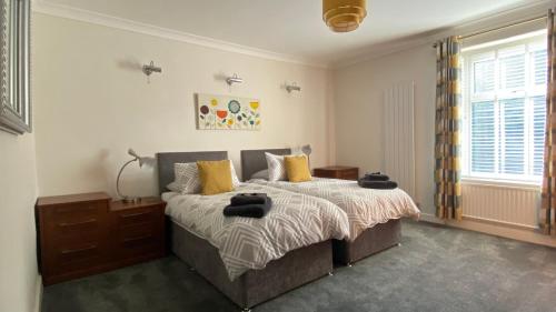 um quarto com uma cama com almofadas amarelas em Riverside Cottage em Whalley